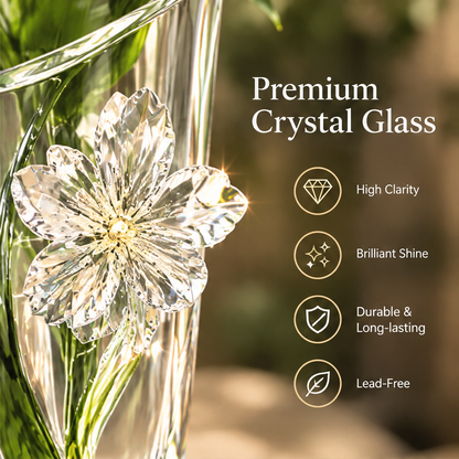 Empty clear vase showing its tapered shape, slanted rim, flower ornament and green-toned accent.