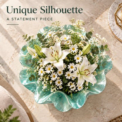 Overhead view of the aqua green vase showing its rippled opening around white flowers.